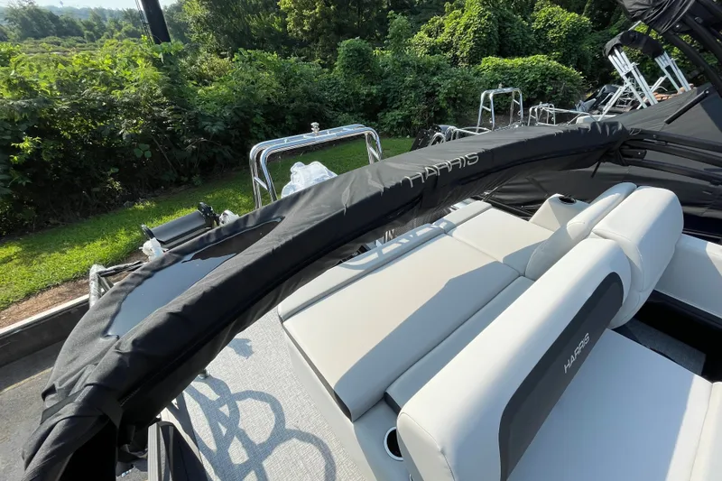Slide: The Image of 2026 Harris Cruiser 210 SLDH pontoon boat with sleek seating and lush greenery backdrop. - 5