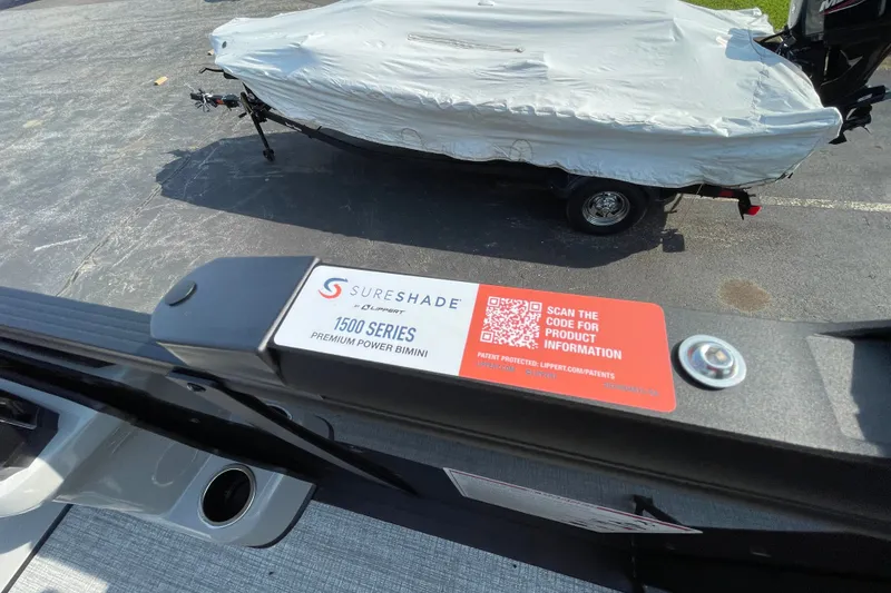 Slide: The Image of 2026 Harris Cruiser 210 SLDH with SureShade 1500 Series Bimini, covered boat in background. - 3