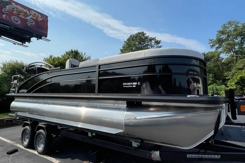 The Image of 2026 Harris Cruiser 210 SLDH pontoon boat on trailer, parked outdoors. - 0