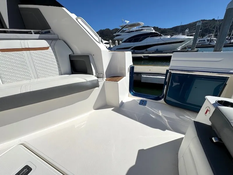 Slide: The Image of The image shows the cockpit of a 2022 Tiara Yachts 43 LE, featuring sleek seating and a clear view of the marina. - 15