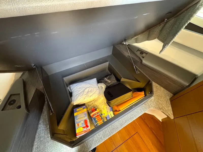 Slide: The Image of A storage compartment on a 2022 Tiara Yachts 43 LE, filled with various items. - 27