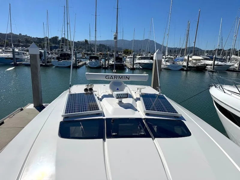 Slide: The Image of The 2022 Tiara Yachts 43 LE is docked in a marina, surrounded by other boats. Solar panels are visible. - 7