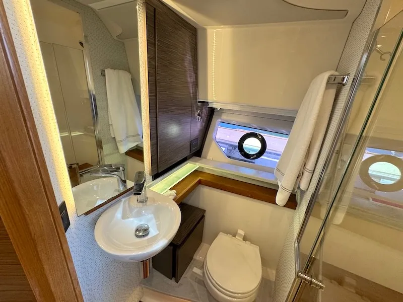 Slide: The Image of The image shows a modern yacht bathroom with a sink, toilet, and window. - 31