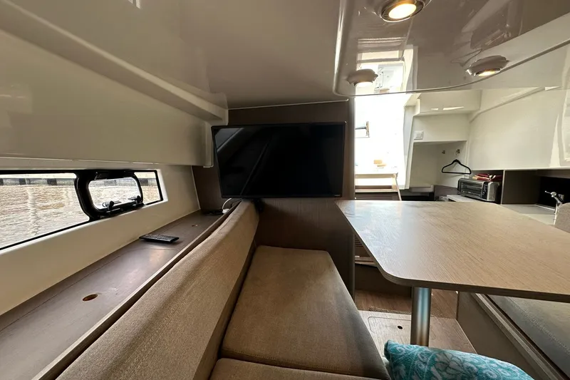 Slide: The Image of Interior of 2024 Beneteau Flyer 9 SUNdeck with seating, table, and window view. - 32