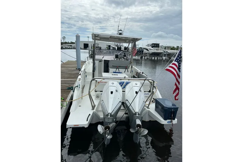 Slide: The Image of 2024 Beneteau Flyer 9 SUNdeck docked, featuring dual outboard motors and American flag. - 13
