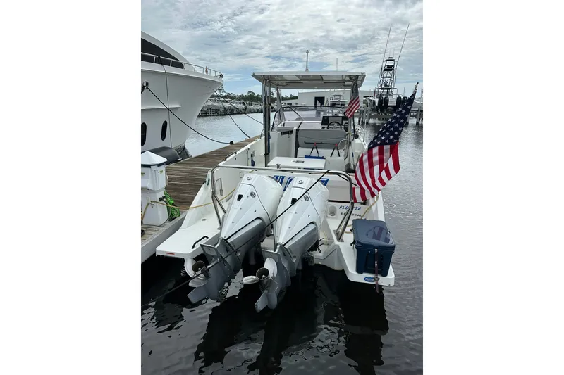 Slide: The Image of 2024 Beneteau Flyer 9 SUNdeck docked, featuring dual outboard motors and American flag. - 14