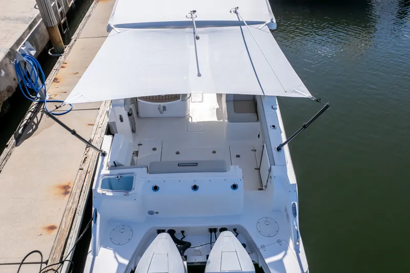 Slide: The Image of 2023 Boston Whaler 280 Vantage boat docked, featuring spacious deck and canopy. - 23