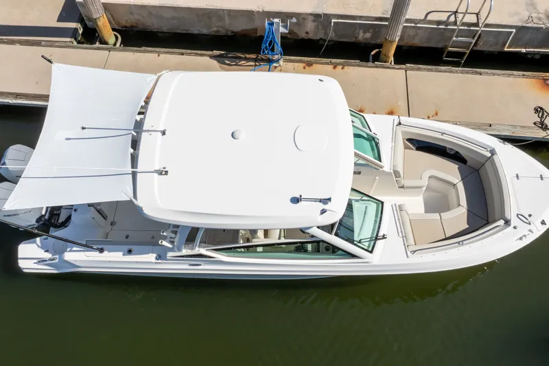 Slide: The Image of 2023 Boston Whaler 280 Vantage boat docked, aerial view showcasing spacious seating and canopy. - 21