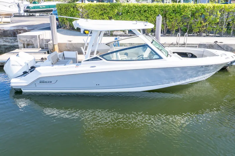 Slide: The Image of 2023 Boston Whaler 280 Vantage boat docked in calm marina waters. - 19