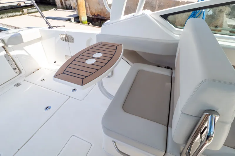 Slide: The Image of 2023 Boston Whaler 280 Vantage boat interior with cushioned seating and foldable table. - 67