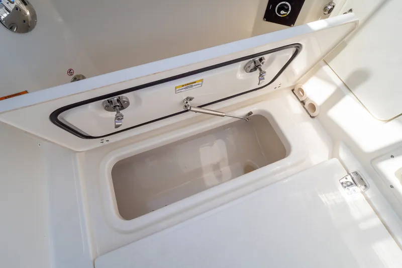 Slide: The Image of 2023 Boston Whaler 280 Vantage storage compartment, open with secure latches and hydraulic support. - 53