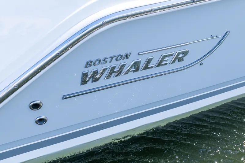 Slide: The Image of 2023 Boston Whaler 280 Vantage boat logo on hull above water. - 30