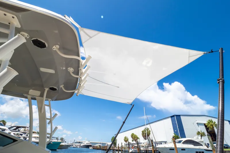 Slide: The Image of 2023 Boston Whaler 280 Vantage boat with sunshade, docked under clear blue sky. - 38