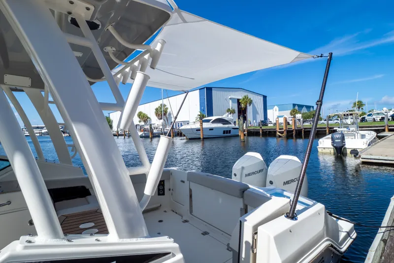 Slide: The Image of 2023 Boston Whaler 280 Vantage docked, showcasing dual Mercury engines and marina backdrop. - 77