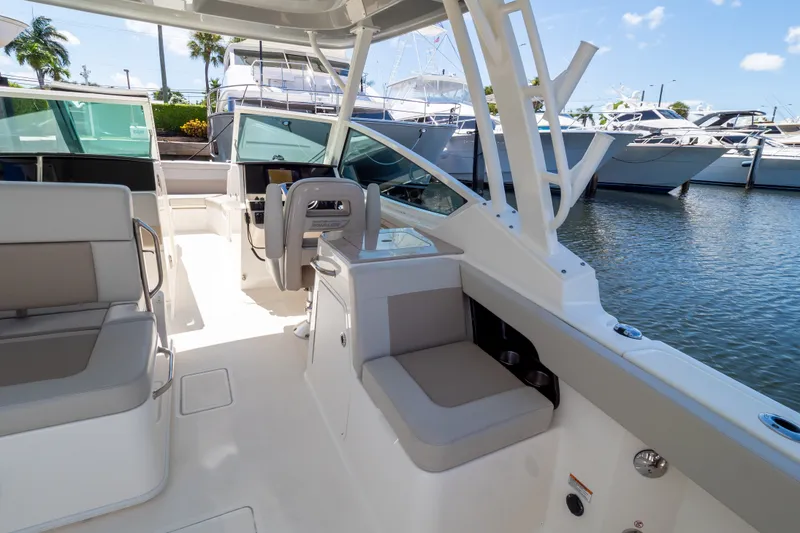 Slide: The Image of 2023 Boston Whaler 280 Vantage boat interior with seating and helm, docked at marina. - 60