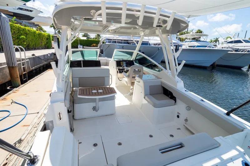 Slide: The Image of 2023 Boston Whaler 280 Vantage boat interior at marina, showcasing seating and helm. - 80
