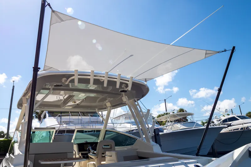 Slide: The Image of 2023 Boston Whaler 280 Vantage boat with sunshade, docked under clear blue sky. - 79