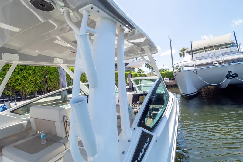 Slide: The Image of 2023 Boston Whaler 280 Vantage boat docked near a catamaran, showcasing sleek design. - 66