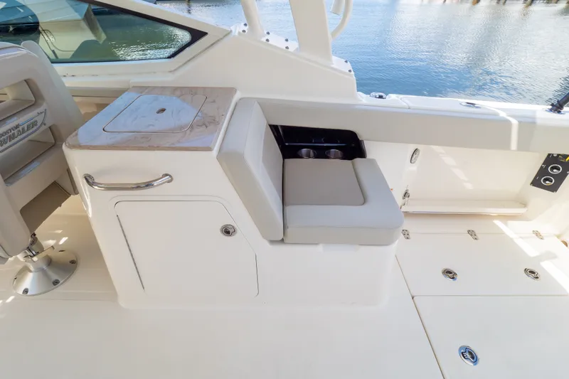 Slide: The Image of 2023 Boston Whaler 280 Vantage interior with seating and storage, overlooking water. - 45