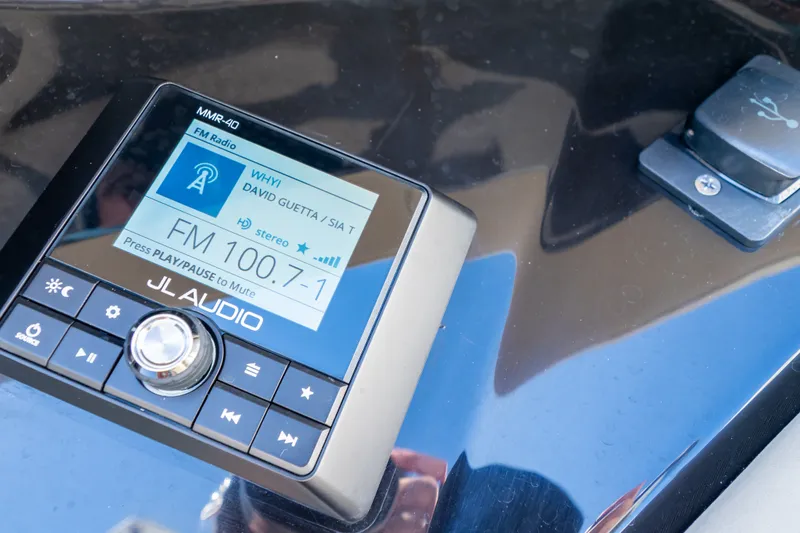 Slide: The Image of JL Audio system on 2023 Boston Whaler 280 Vantage, displaying FM radio station 100.7. - 90