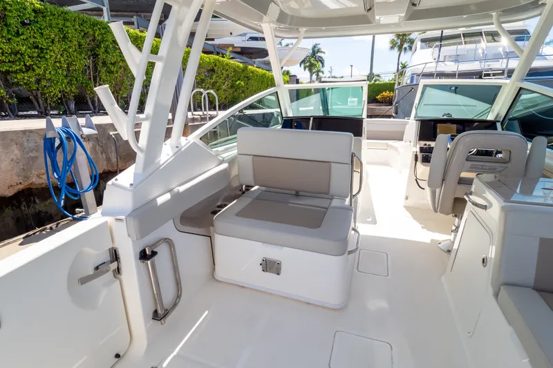 Slide: The Image of 2023 Boston Whaler 280 Vantage boat interior with seating and helm, docked outdoors. - 59