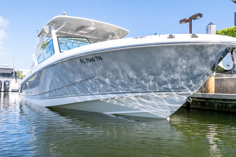 Slide: The Image of 2023 Boston Whaler 280 Vantage boat docked, reflecting sunlight on water. - 25