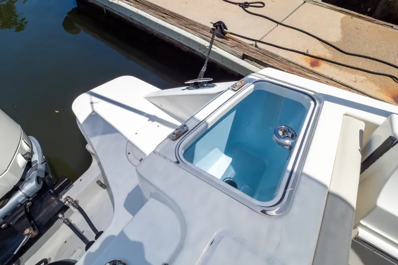 Slide: The Image of 2023 Boston Whaler 280 Vantage boat with open storage compartment at dockside. - 33