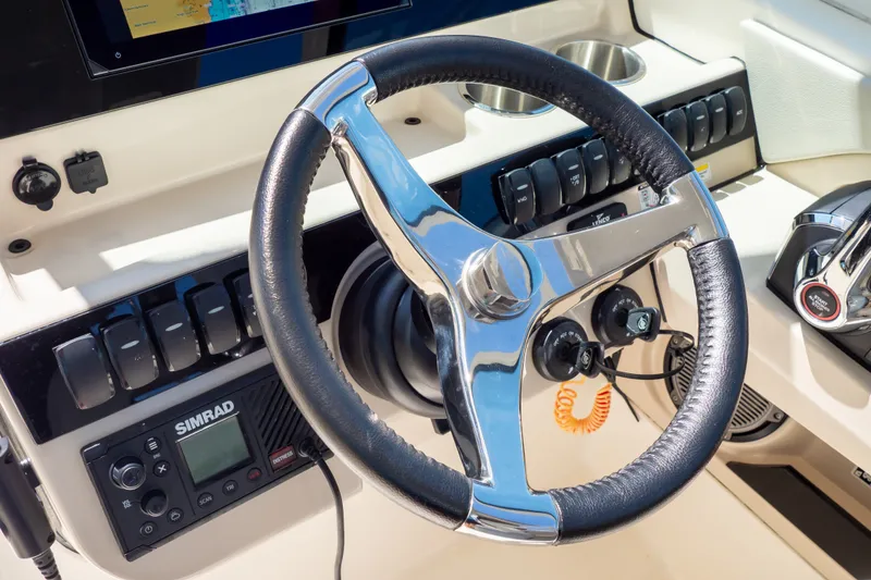 Slide: The Image of Steering wheel and controls of 2023 Boston Whaler 280 Vantage boat cockpit. - 13