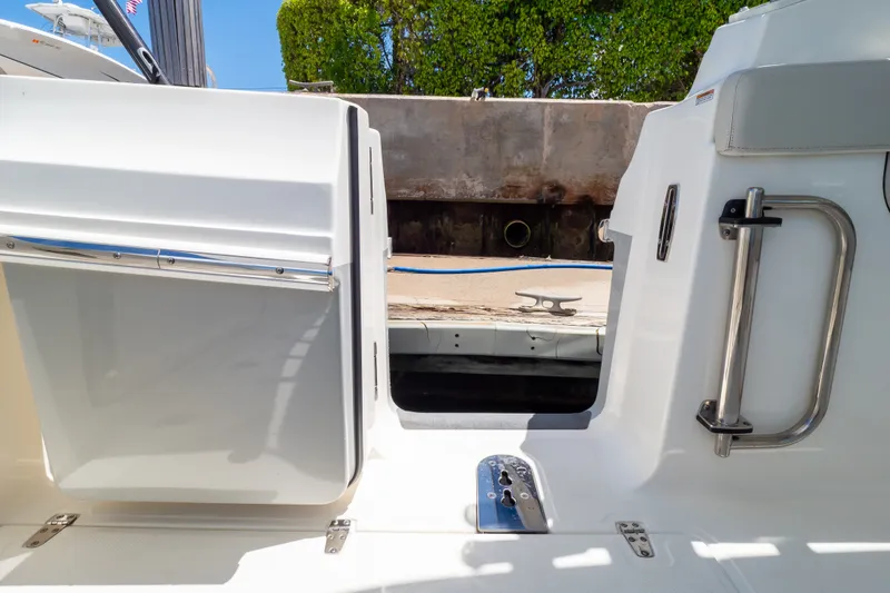 Slide: The Image of 2023 Boston Whaler 280 Vantage boat entryway with stainless steel handle and dock view. - 37