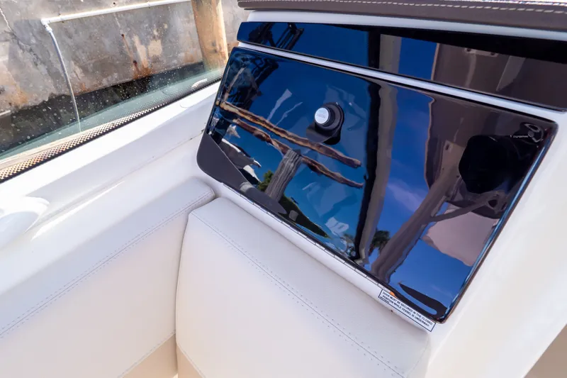 Slide: The Image of 2023 Boston Whaler 280 Vantage interior detail with sleek, reflective panel and cushioned seating. - 83