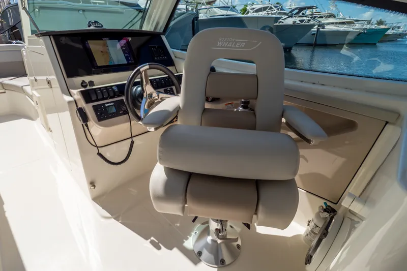 Slide: The Image of Captain's chair and helm of 2023 Boston Whaler 280 Vantage boat, featuring modern controls. - 69