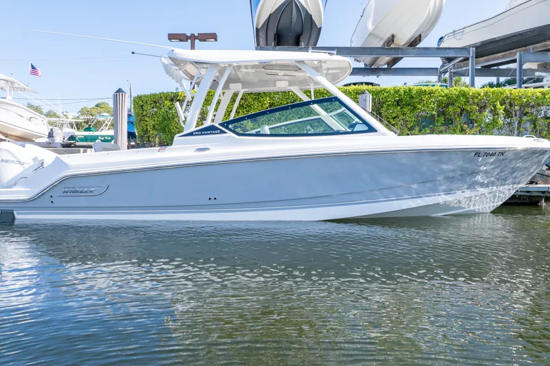 Slide: The Image of 2023 Boston Whaler 280 Vantage boat docked on calm water, side view. - 20