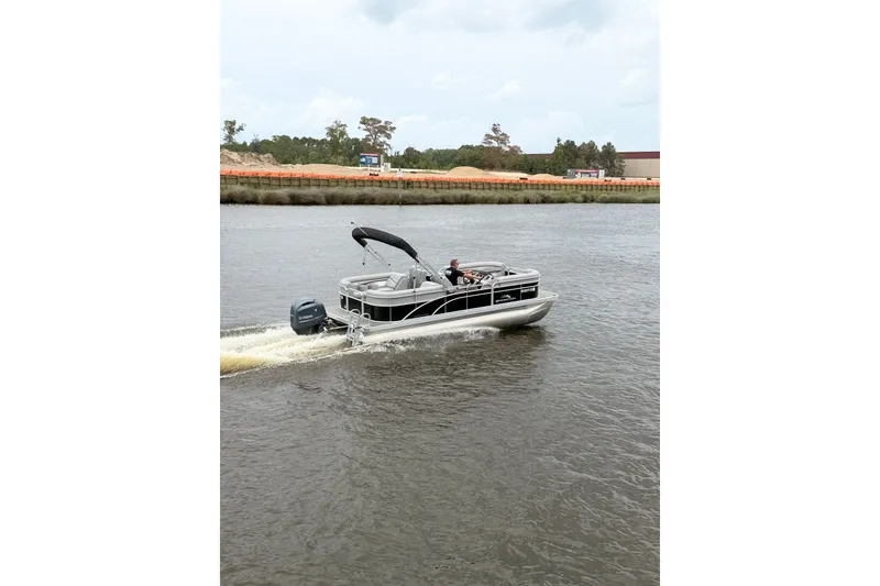 Slide: The Image of 2023 Bennington 22 SV pontoon boat cruising on a calm river. - 8