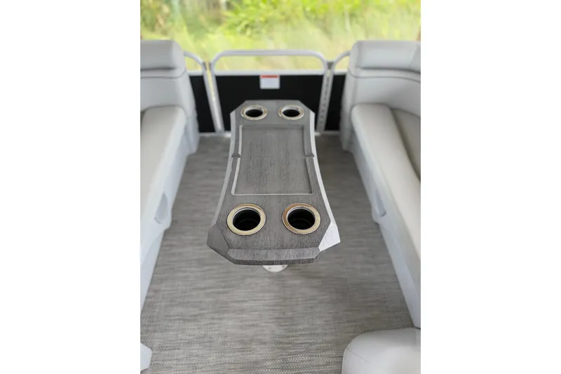 Slide: The Image of 2023 Bennington 22 SV interior with table and cup holders, surrounded by cushioned seating. - 20