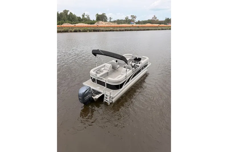 Slide: The Image of 2023 Bennington 22 SV pontoon boat on calm water, featuring a sleek design. - 2