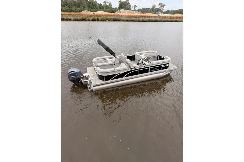 Slide: The Image of 2023 Bennington 22 SV pontoon boat on calm water, featuring sleek design and Yamaha outboard motor. - 3