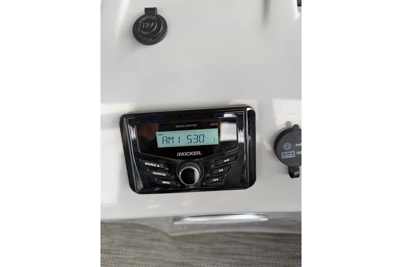 Slide: The Image of 2023 Bennington 22 SV boat dashboard featuring Kicker media center and USB audio input. - 26