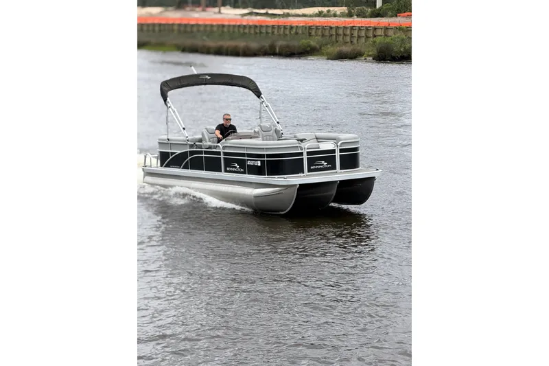 Slide: The Image of 2023 Bennington 22 SV pontoon boat cruising on a river. - 5
