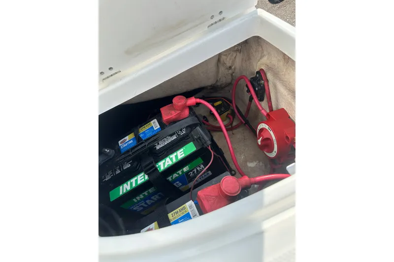 Slide: The Image of Battery compartment of 2023 Hurricane SunDeck Sport 192 RL OB with red cables and switch. - 29