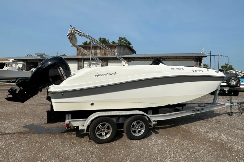 Slide: The Image of 2023 Hurricane SunDeck Sport 192 RL OB boat on trailer, parked outdoors. - 2