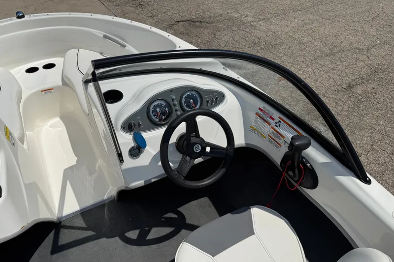 Slide: The Image of 2019 Bayliner 160 Bowrider cockpit with steering wheel and dashboard controls. - 14