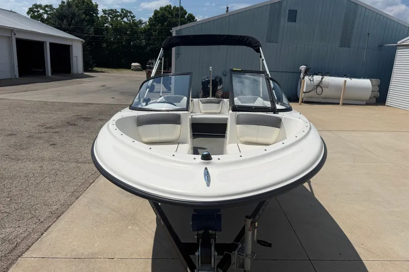 Slide: The Image of 2019 Bayliner 160 Bowrider boat parked outdoors on a sunny day. - 2