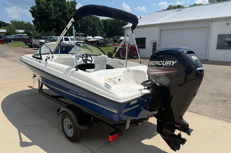 Slide: The Image of 2019 Bayliner 160 Bowrider with Mercury outboard motor, parked outdoors on a sunny day. - 5
