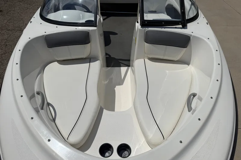 Slide: The Image of 2019 Bayliner 160 Bowrider boat interior with white seating and cup holders. - 8