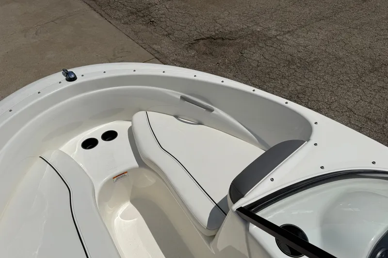Slide: The Image of 2019 Bayliner 160 Bowrider boat interior with white seating and cup holders. - 9