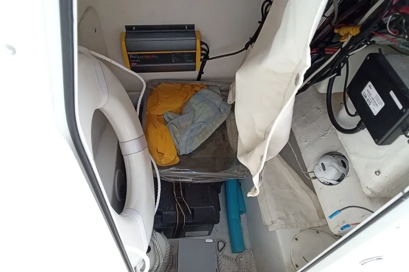 Slide: The Image of 2009 Sea Hunt Ultra 232 boat storage area with life preserver and equipment. - 23