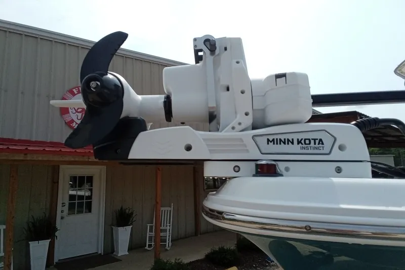 Slide: The Image of Minn Kota Instinct motor on 2009 Sea Hunt Ultra 232 boat, docked near a building. - 8
