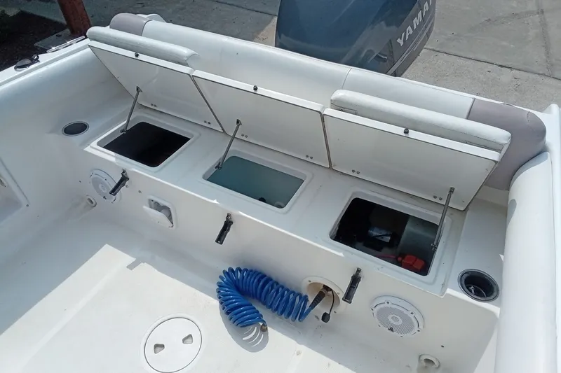 Slide: The Image of 2009 Sea Hunt Ultra 232 boat deck with storage compartments and Yamaha engine. - 14