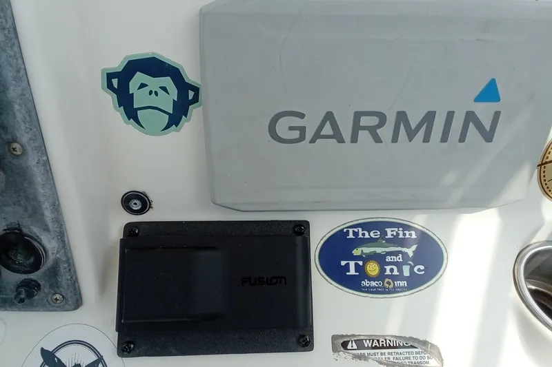 Slide: The Image of 2009 Sea Hunt Ultra 232 dashboard with Garmin and Fusion equipment, featuring stickers. - 33