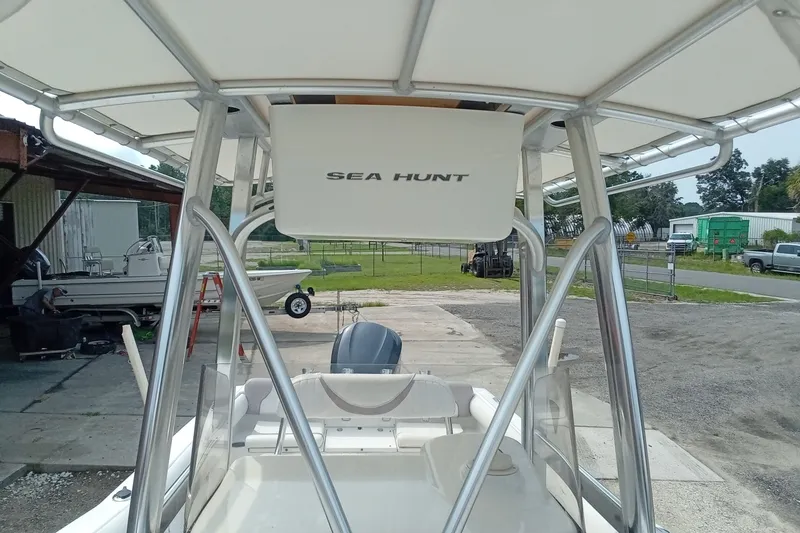 Slide: The Image of 2009 Sea Hunt Ultra 232 boat with T-top and outboard motor in a marina setting. - 27